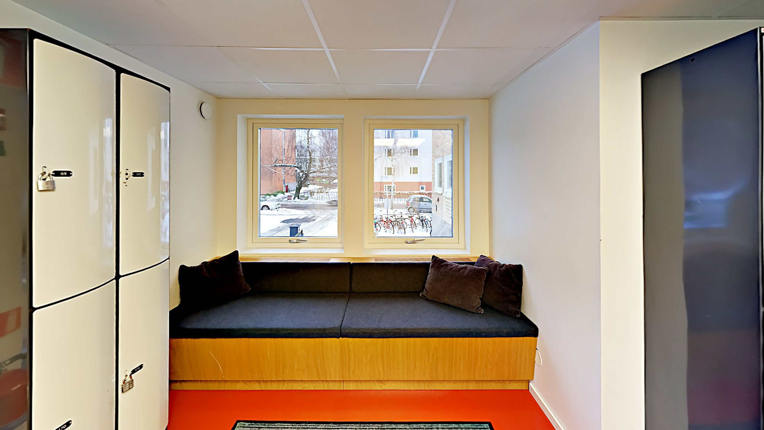 I korridoren har det skapats en skön plats med inbyggd soffa framför fönstret.